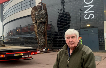 Cllr Keith McLean stands in front of Knife Angel statue 